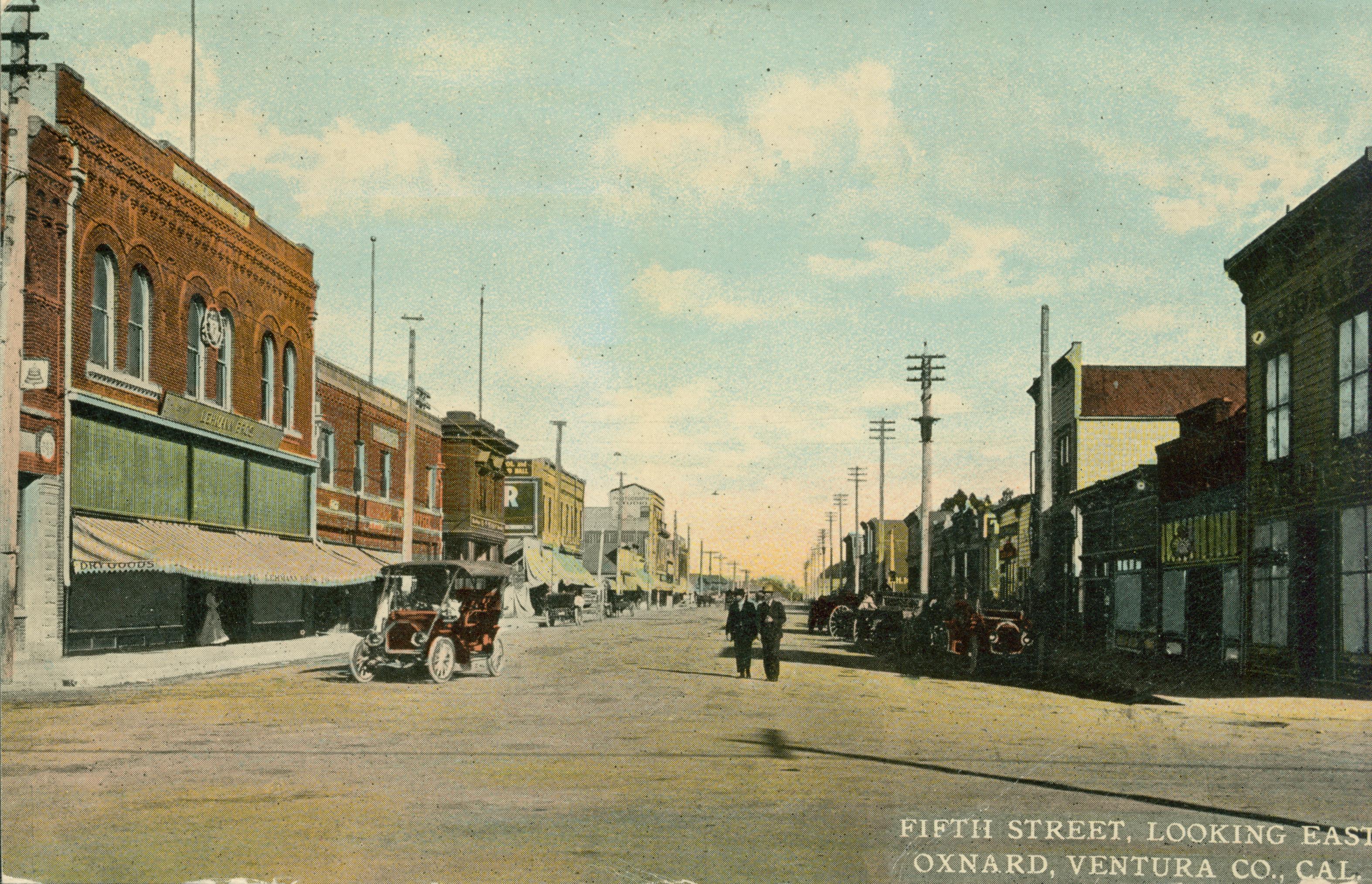 Shows Fifth street in Oxnard lined with buildings and several parked cars
